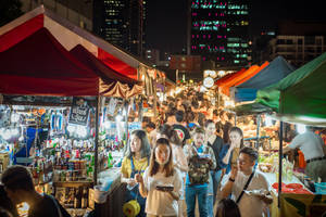 夜市，人群在色彩繽紛的帳篷和燈光下購物。 — 唐人街 GIF 壁紙