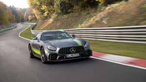 銀色 Mercedes-AMG GT 在秋季彎曲的森林道路上疾馳。