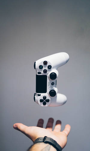 一個白色遊戲手掣在張開的手上漂浮。