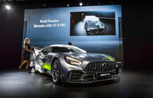 一位女士在舞台上揭開銀色 Mercedes-AMG GT R PRO 跑車。
