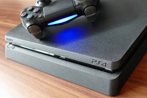 木桌上帶有藍光控制器的黑色PlayStation 4主機