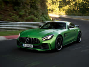 綠色Mercedes-AMG GT R在森林道路上疾馳，動態模糊。 — 汽車 壁紙