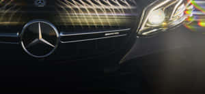 黑色 Mercedes-AMG 車頭特寫，帶有發光光條和鏡頭光暈。 — 平治 C300 壁紙