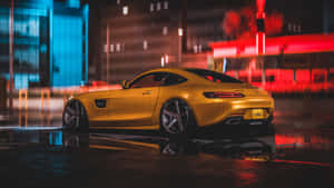 金色跑車停在夜間濕漉漉的城市街道上，帶有霓虹燈反射。 — 城市 壁紙