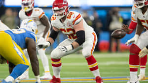 NFL足球運動員在比賽期間於綠色球場上行動。