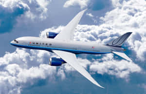 聯合航空噴射機在晴朗的日子穿過雲層飛行。