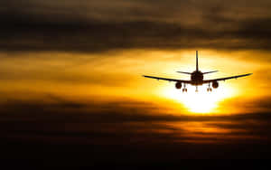 飛機飛入金色日落與雲層