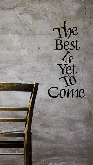 一張木椅旁邊的牆上寫著 The Best Is Yet To Come。