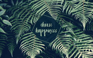 蕨類葉片圍繞著一個深色六邊形，上面有草書短語 choose happiness。