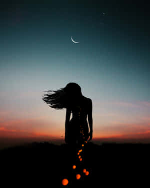 女人在彎月和繁星暮色下，頭髮被風吹起的剪影。