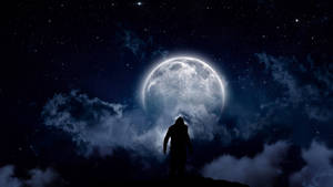 懸崖上的人影剪影，夜間透過雲層凝視大月亮。 — 暗色 4K 壁紙