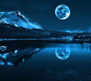滿月映照在積雪的山峰上，倒映在夜晚平靜的湖面。 — 月色夜空 壁紙