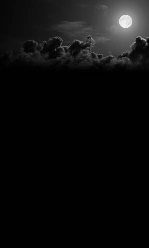 滿月穿過烏雲照耀，黑白夜空。