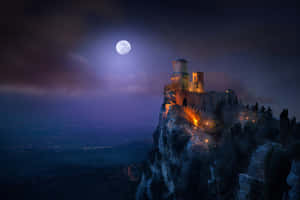 滿月下夜晚被照亮的古城俯瞰山谷。 — 月色夜空 壁紙