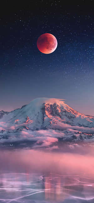 血月映照在積雪的山峰上，夜晚倒映在霧濛濛的山谷中。 — 月色夜空 壁紙