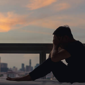夕陽下，陽台床上，雙手掩面，俯瞰城市的人。 — 鼓舞人心的 壁紙