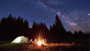 一群朋友在星空下享受營火，銀河清晰可見。