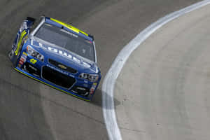 藍黃色NASCAR賽車編號48在賽道上過彎。