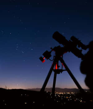 望遠鏡剪影映襯星空，下方城市燈光。