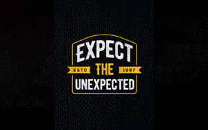 大膽的勵志文字標誌，上面寫著「Expect the Unexpected」，並帶有「ESTD 1997」，位於紋理深色背景上。