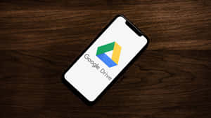 智能手機在木桌上顯示Google Drive標誌