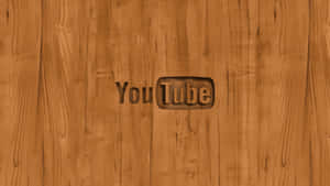 YouTube 標誌雕刻在木質表面上，可見木紋。