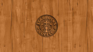 Starbucks 咖啡標誌雕刻在木質表面上。