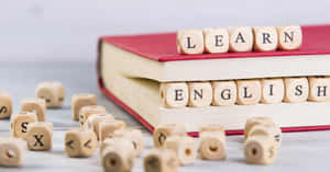木製方塊在紅色書本上拼出learn english，用於語言學習。 — 美景 壁紙