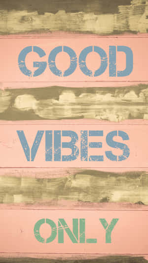 風化木牌上以藍色和綠色的模板文字寫著 good vibes only。