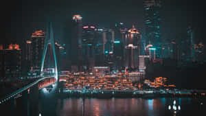 夜晚，一座發光的橋樑橫跨河流，背後是燈火通明的摩天大樓天際線。 — 夜晚 GIF 壁紙