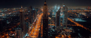 現代城市的夜間航拍，發光的摩天大樓和繁忙的道路。 — 夜晚 GIF 壁紙