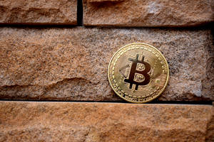 石牆表面上的金色比特幣硬幣。