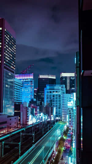 霓虹燈照亮的夜間城市天際線，發光的建築物和潮濕的街道。