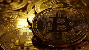 在溫暖光線下帶有電路圖案的金色比特幣硬幣堆。 — 比特幣 壁紙