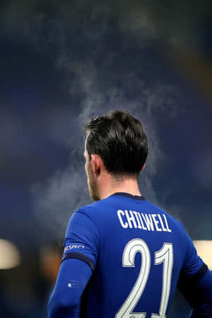 足球員Chilwell身穿藍色21號球衣，夜間頭部周圍有煙霧。