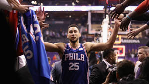 籃球運動員賽後身穿藍色PHILA球衣與球迷擊掌。