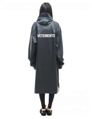 穿著背面有白色VETEMENTS文字的黑色雨衣的人。