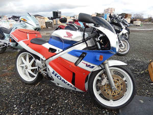 紅色、白色和藍色的本田CBR1100XX運動電單車停泊在廢車場。