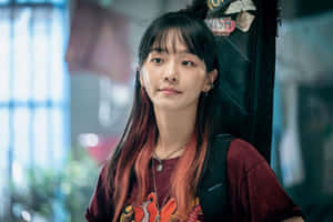年輕女性，紅髮梢，揹著背包，站在城市小巷中。