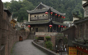 古老的中國街道，有石徑和紅色燈籠，背景是綠色山丘。 — 唐人街 GIF 壁紙
