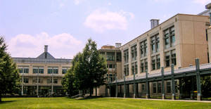 大學校園，現代建築，綠色草坪和樹木，藍天白雲。