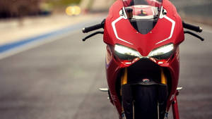 黃昏時分，賽道上紅色Ducati電單車，車頭燈閃爍發光。