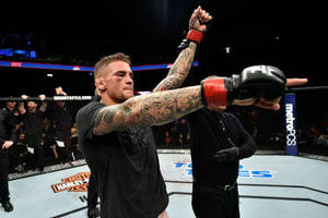 MMA戰士在八角籠中舉拳慶祝勝利。