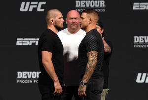 兩名男性MMA拳手在UFC稱重儀式上由裁判隔開，互相對峙。