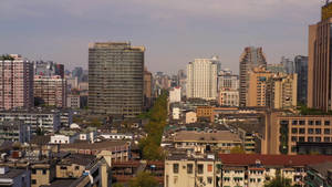 朦朧天空下現代與傳統建築交織的城市天際線 — 湖景 壁紙