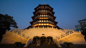 暮色中發光的寶塔，一人踏上石階 — 湖景 壁紙
