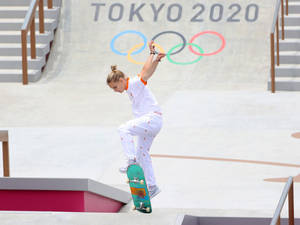 女滑板選手在東京2020奧運會滑板公園中表演技巧。