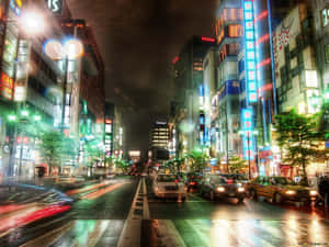 霓虹燈照亮了夜晚濕漉漉的東京街道，車輛穿梭其中。 — 城市 壁紙