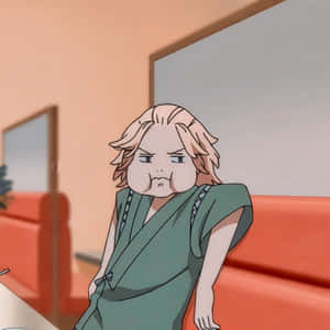 金髮綠袍動漫角色靠在紅色沙發上，表情不高興。 — Mikey 東京復仇者 GIF 壁紙