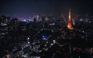 東京鐵塔在夜晚被城市燈光環繞照亮。